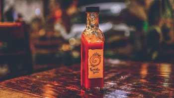 Selective Focus Photo of Tomato Sauce Bottle on Top of Brown Table