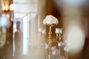 Selective Focus Photo of White Flowers in Brass-colored Candelabra With Votive Candles on Table