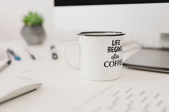 selective focus photo of white mug near wireless mouse