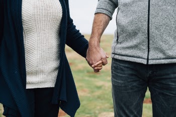 Selective Focus Photo of Woman and Man Holding Each Other Hands