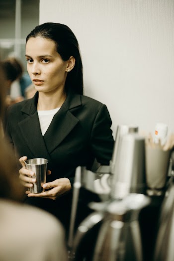 Selective Focus Photo of Woman Holding Silver Cup