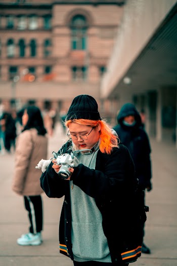 Selective Focus Photo of Woman Holding White Dslr Camera