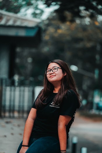 Selective Focus Photo of Woman in Black T-shirt Sitting While Looking up