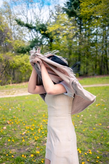 Selective Focus Photo of Woman  in Dress Covering a Head with a Gray Apparel  Standing on Green Grass Field