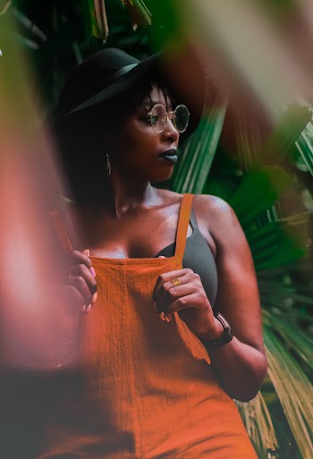 Selective Focus Photo of Woman in Orange Outfit Posing While Looking Away