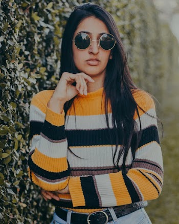 Selective Focus Photo of Woman in Sunglasses Standing Beside Hedge