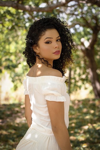 Selective Focus Photo of Woman in White Dress Posing with Trees in the Background
