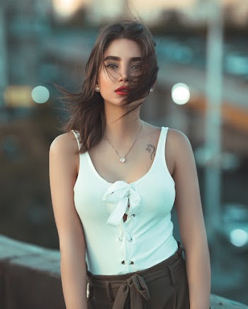 Selective Focus Photo of Woman in White Sleeveless Top Posing
