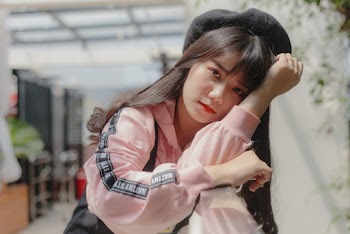 Selective Focus Photo of Woman Leaning on Metal Railing
