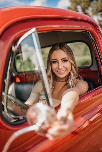 Selective Focus Photo of Woman Sitting Inside Red Vehicle