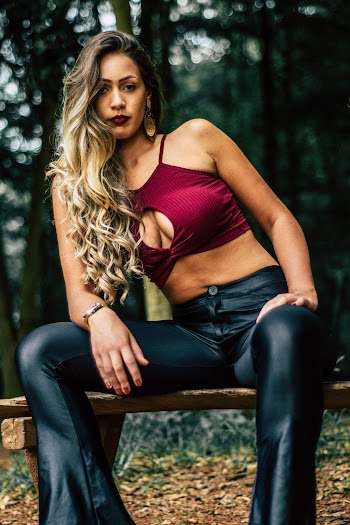 Selective Focus Photo of Woman Sitting on Wooden Bench Posing