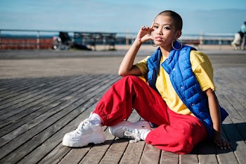 Selective Focus Photo of Woman Sitting on Wooden Floor Posing