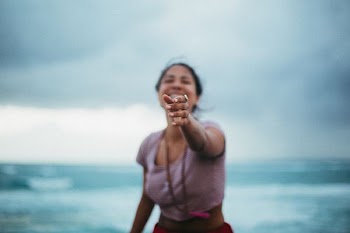 selective focus photo of woman standing near beach