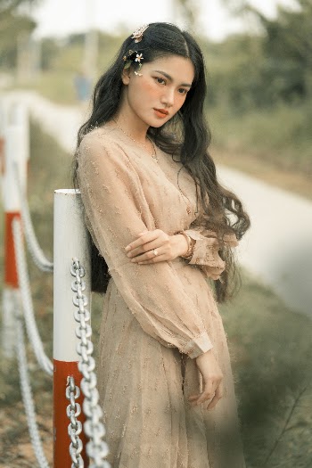 Selective Focus Photo of Woman Standing Near Metal Fence