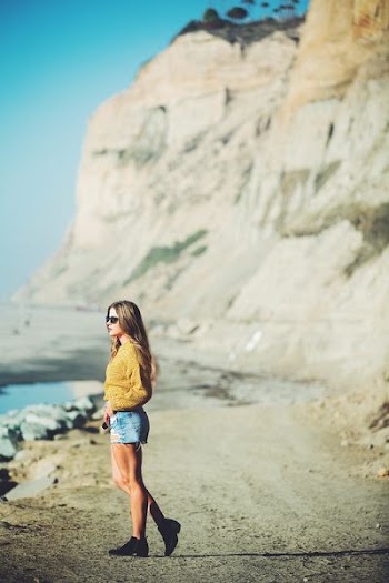 selective focus photo of woman standing near mountain