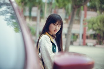 Selective Focus Photo of Woman Standing Next to Parked Car