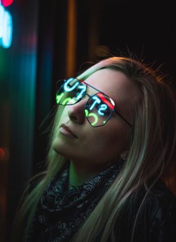 selective focus photo of woman staring at LED sign