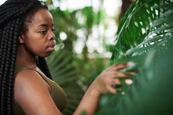 Selective Focus Photo of Woman Touching Green Leaves