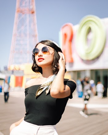 Selective Focus Photo of Woman Wearing Black Off-shoulder Top and Sunglasses