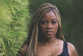 Selective Focus Photo of Woman With Braided Hair Standing Beside Plant