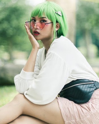 Selective Focus Photo of Woman with Green Hair Posing While Sitting Down