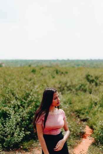 Selective Focus Photo Woman Pink Off-shoulder Top and Black Skirt Looking Away with Green Plants in the Background