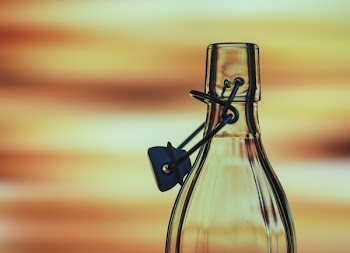 Selective Focus Photography Clear Swing Top Glass Bottle