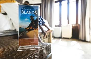 Selective Focus Photography Islands Card on Brown Wicker Table