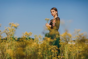 Selective Focus Photography of a Woman Standing on a Flower Field