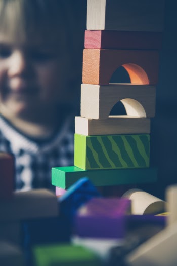 Selective Focus Photography of Beige Orange Red and Green Blocks Piled Vertically