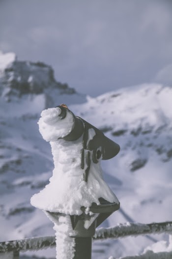 Selective Focus Photography of Black Camera Covered With Snow