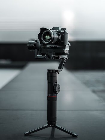 selective focus photography of black DSLR camera with camera tripod