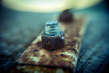 Selective Focus Photography of Brown Steel Knot on Brown Metal Plate