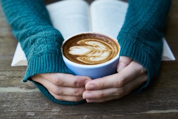 Selective Focus Photography of Cafe Latte in Cup Near Book on Table
