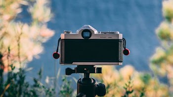 selective focus photography of camera on tripo