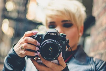 Selective Focus Photography of Canon Dslr Camera Held by Woman