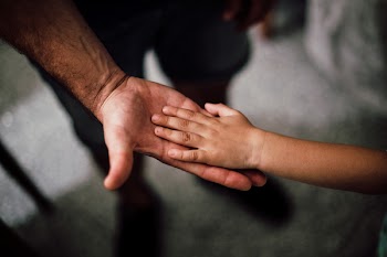 Selective Focus Photography of Child's Hand on Person's Palm