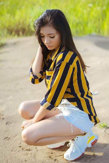 Selective Focus Photography of Crouching Woman Holding Hair