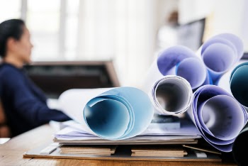 Selective Focus Photography of Desk Full of Rolled Papers 