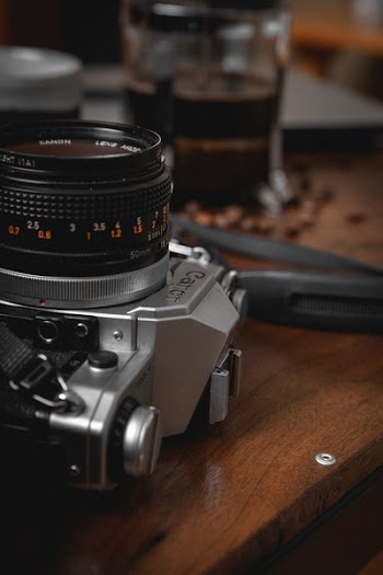 Selective Focus Photography Of Dslr Camera On Table