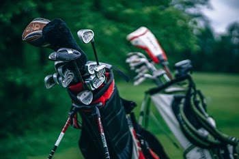 selective focus photography of golf bag with golf clubs