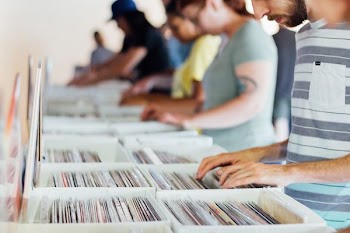 selective focus photography of group of people selecting vinyl record sleeves