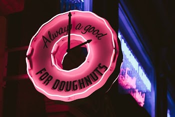 selective focus photography of lighted always a good for doughnuts clock signage