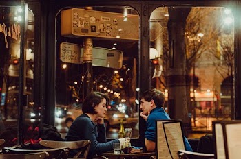 Selective Focus Photography of Man and Woman Sitting on Chair Inside Restaurant during Nighttime