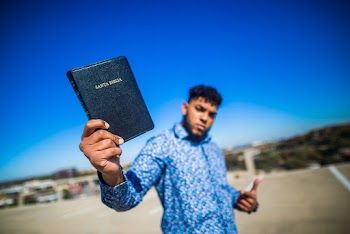 Selective Focus Photography of Man Holding Book