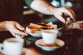 Selective Focus Photography of Man Holding Bowl of Pastry and Condiment Container