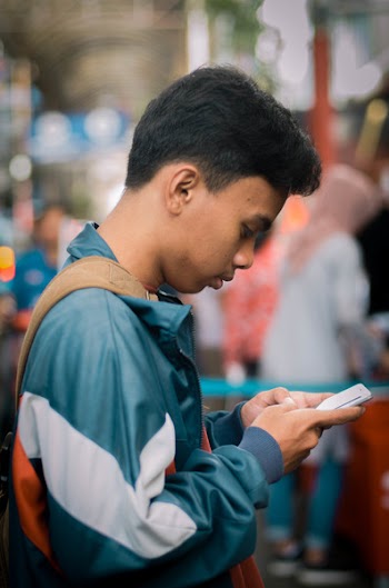 Selective Focus Photography Of Man Holding Smartphone