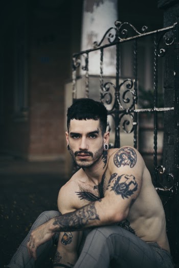 Selective Focus Photography of Man Sitting Against Door