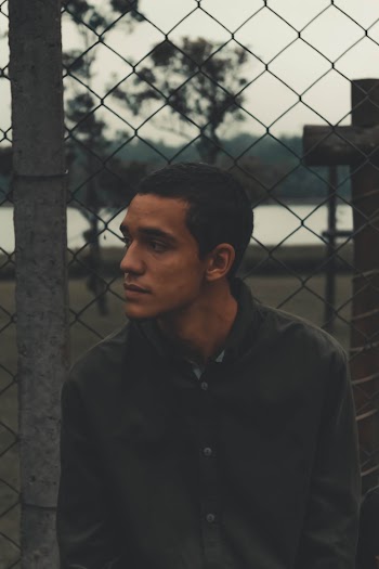 Selective Focus Photography of Man Sitting Near Gray Frame