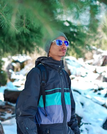 Selective Focus Photography of Man Standing Beside Green Tree